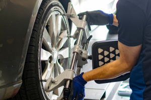Mechanic performing a wheel alignment on a car