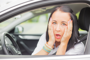 Frustrated driver reacting after hitting a pothole